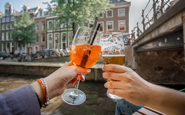 Cheers with drinks on an Amsterdam canal cruise.