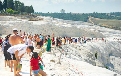 Tourists exploring the travertine terraces of Pamukkale, Turkey.