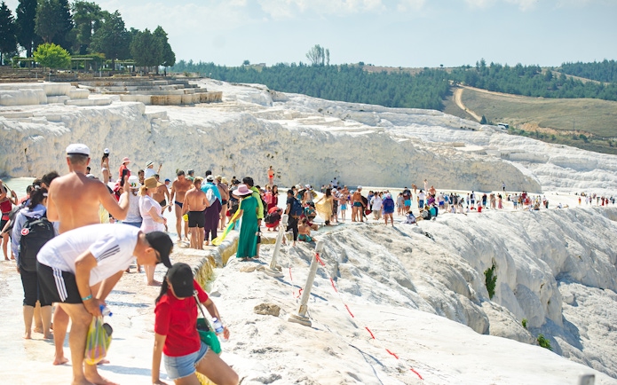 Tourists exploring the travertine terraces of Pamukkale, Turkey.