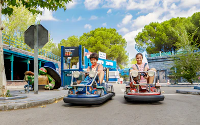 Children driving bumper cars at Parque de Atracciones de Madrid with TMNT theme.