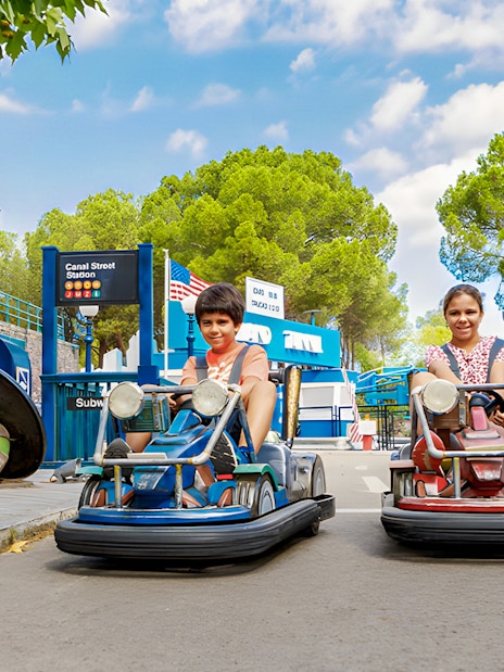 Children driving bumper cars at Parque de Atracciones de Madrid with TMNT theme.