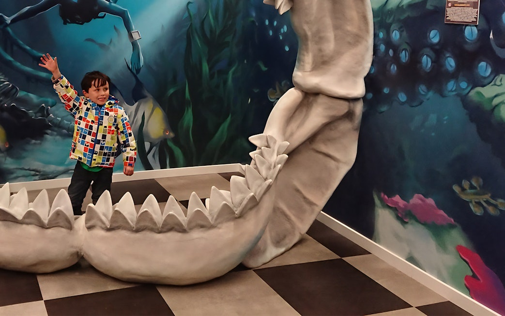 Child playing inside giant jaws exhibit at Big Fun Museum, Barcelona.