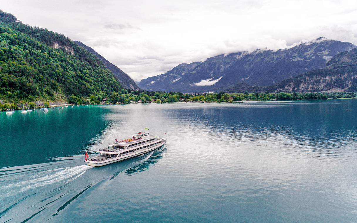 Tour boat crossing Lake Brienz with Swiss Alps in the background.