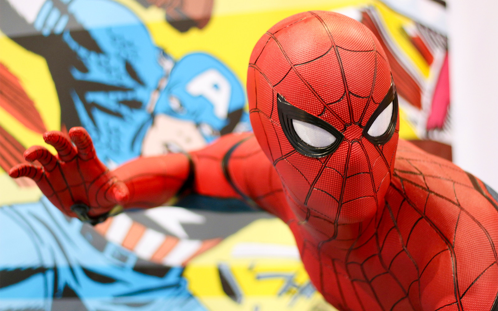 Spider-Man figurine in action pose with comic book background.