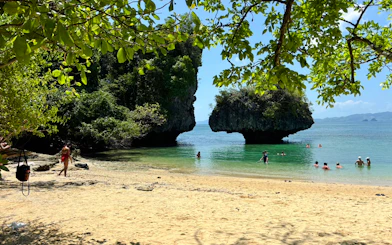 Visitors swimming near limestone formations at Hong Islands beach, Krabi.