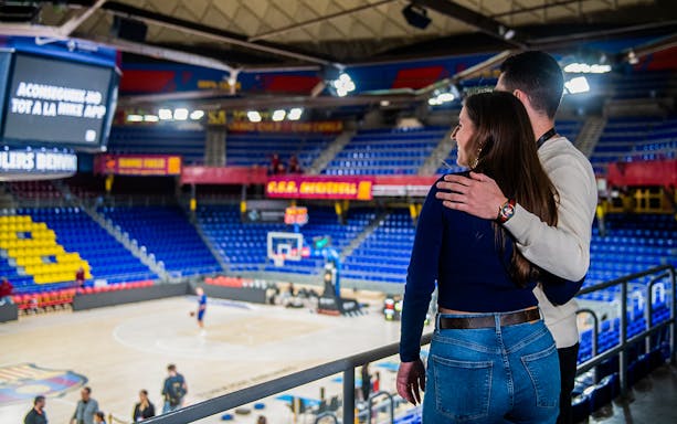 Couple overlooking basketball court at FC Barcelona Palau during immersive tour experience.