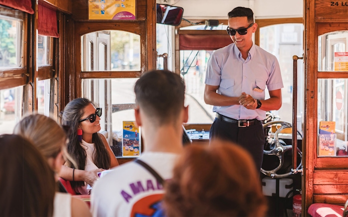Tram conductor addressing passengers inside a Lisbon tram.