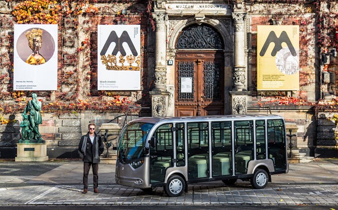 Electric car parked outside the National Museum in Wroclaw during a group tour.