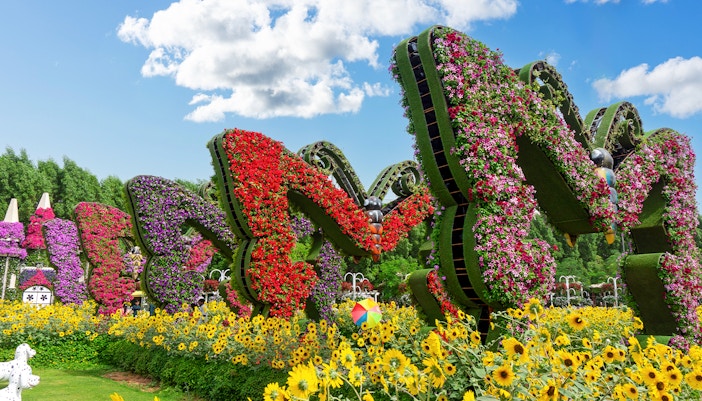 Butterfly-shaped flower sculptures at Dubai Butterfly Garden surrounded by sunflowers.