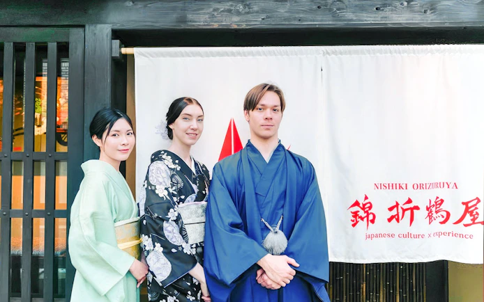 Tourists in traditional attire outside a Japanese tea ceremony venue.
