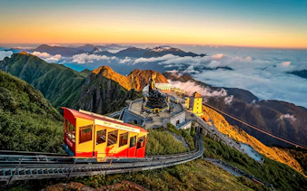 Cable car ascending Fansipan Mountain with temple and statue at Sun World Fansipan Legend, Vietnam.