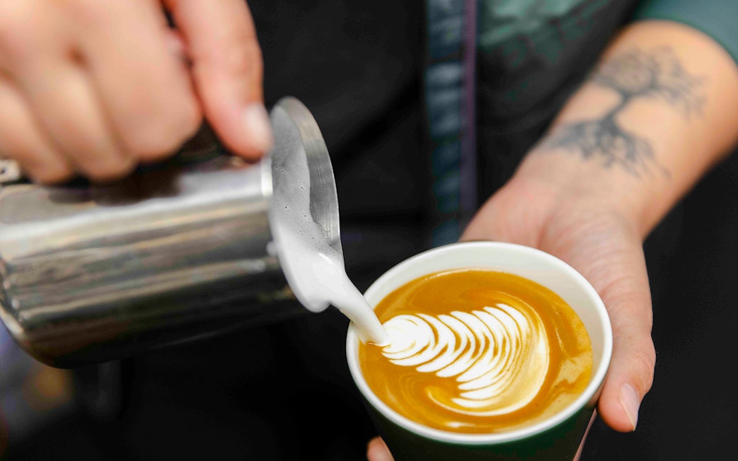 Pouring latte art into a cup on Milford Sound Day Cruise.