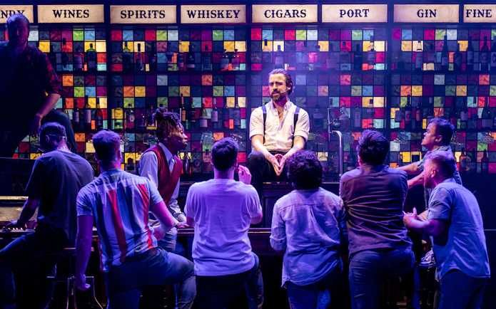 Men performing on stage at a bar setting in The Choir of Man show.