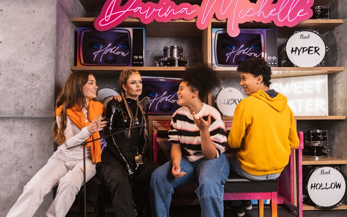 Visitors interacting with Davina Michelle wax figure at Madame Tussauds Amsterdam.