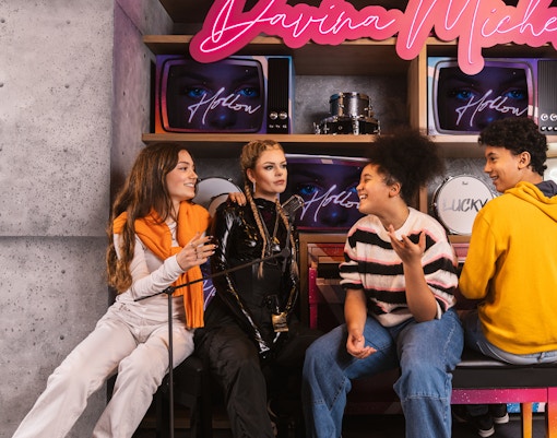 Visitors interacting with Davina Michelle wax figure at Madame Tussauds Amsterdam.