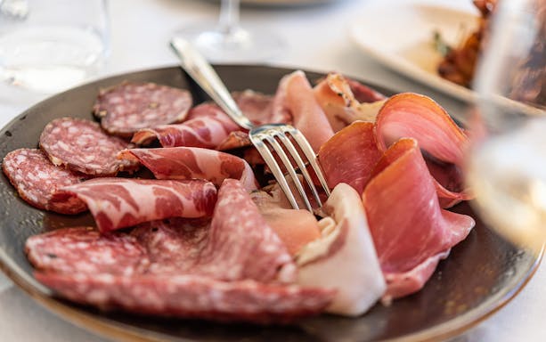 Cured meats platter with fork on Sunset Food Tour in Trastevere.
