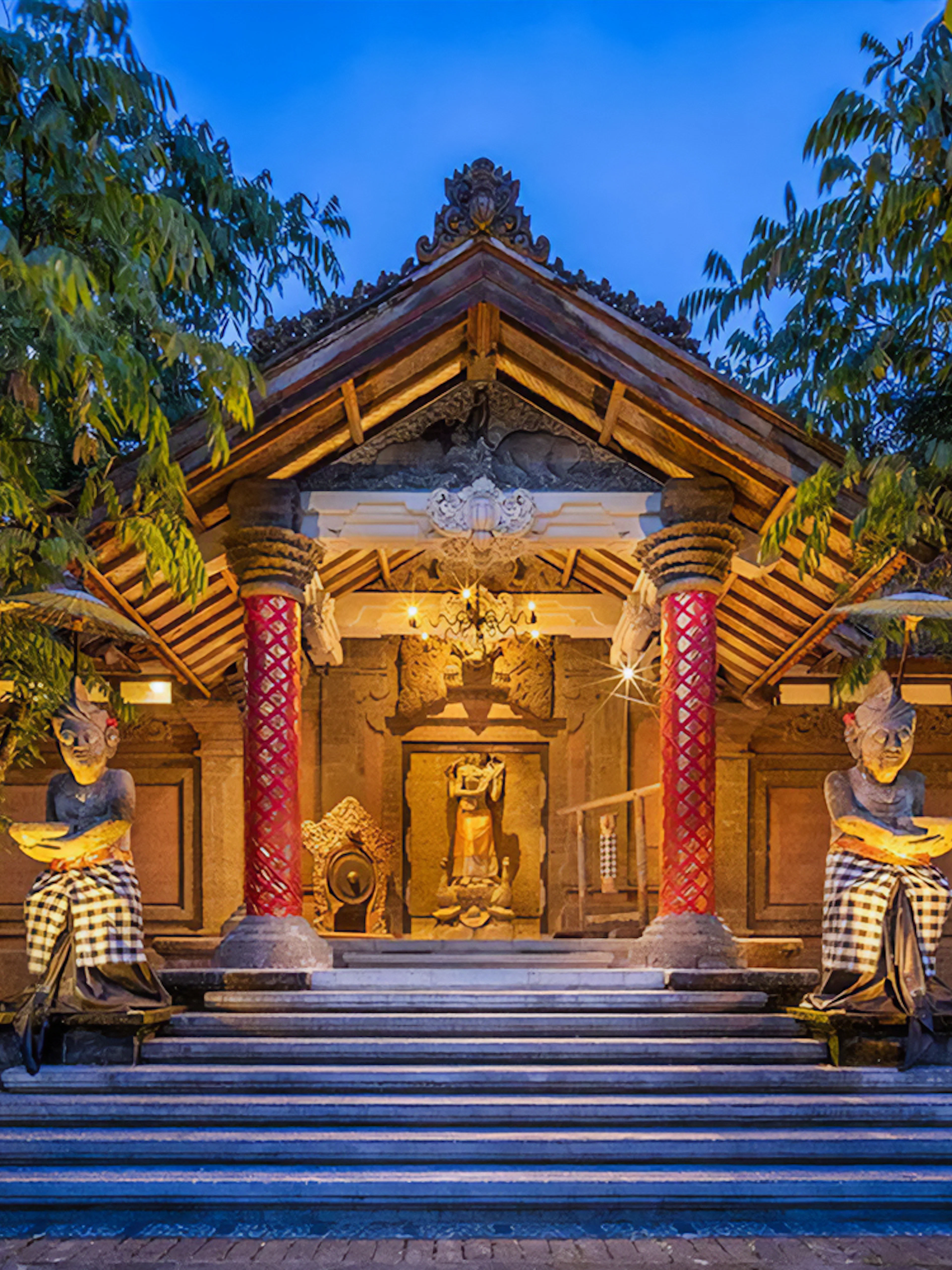 Arma Museum Resort entrance with statues and evening lighting in Bali.