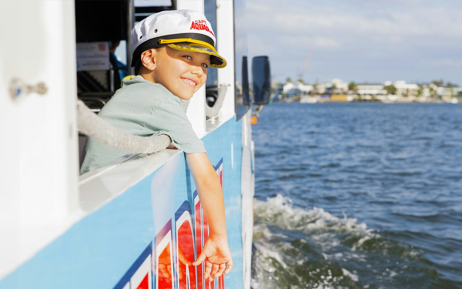 Child enjoying Aquaduck city tour and river cruise, leaning out of the boat.