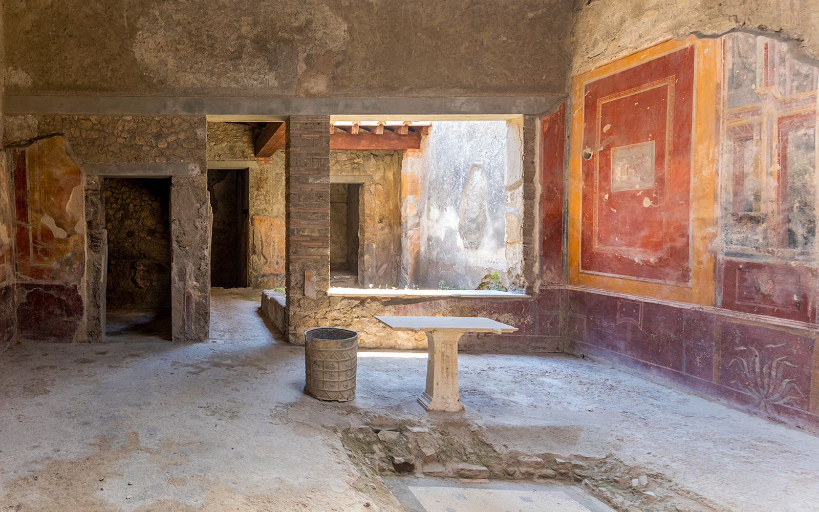 Interior of ancient Pompeii building with frescoes and stone walls, Italy.