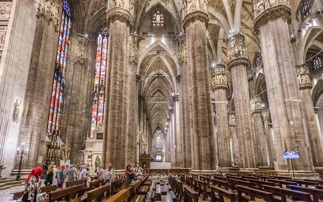 Duomo Cathedral interior in Milan with ornate columns and detailed ceiling.