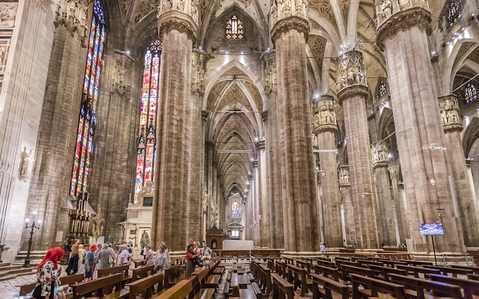Duomo Cathedral interior in Milan with ornate columns and detailed ceiling.