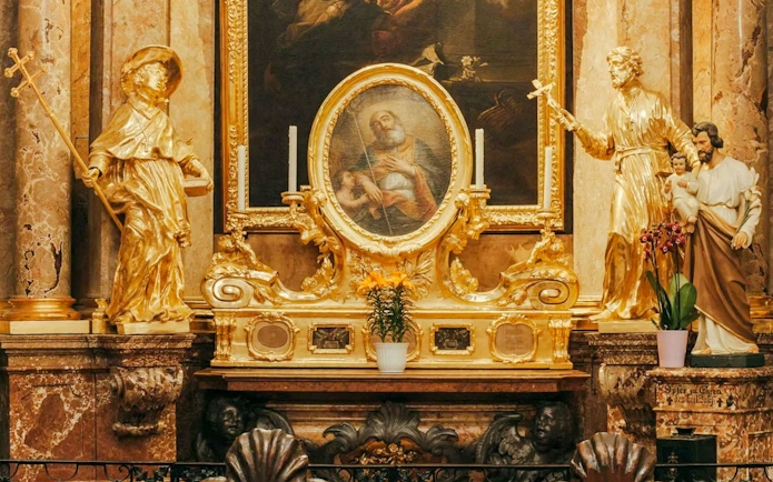 Golden altar with religious statues and painting inside St Anne's Church.