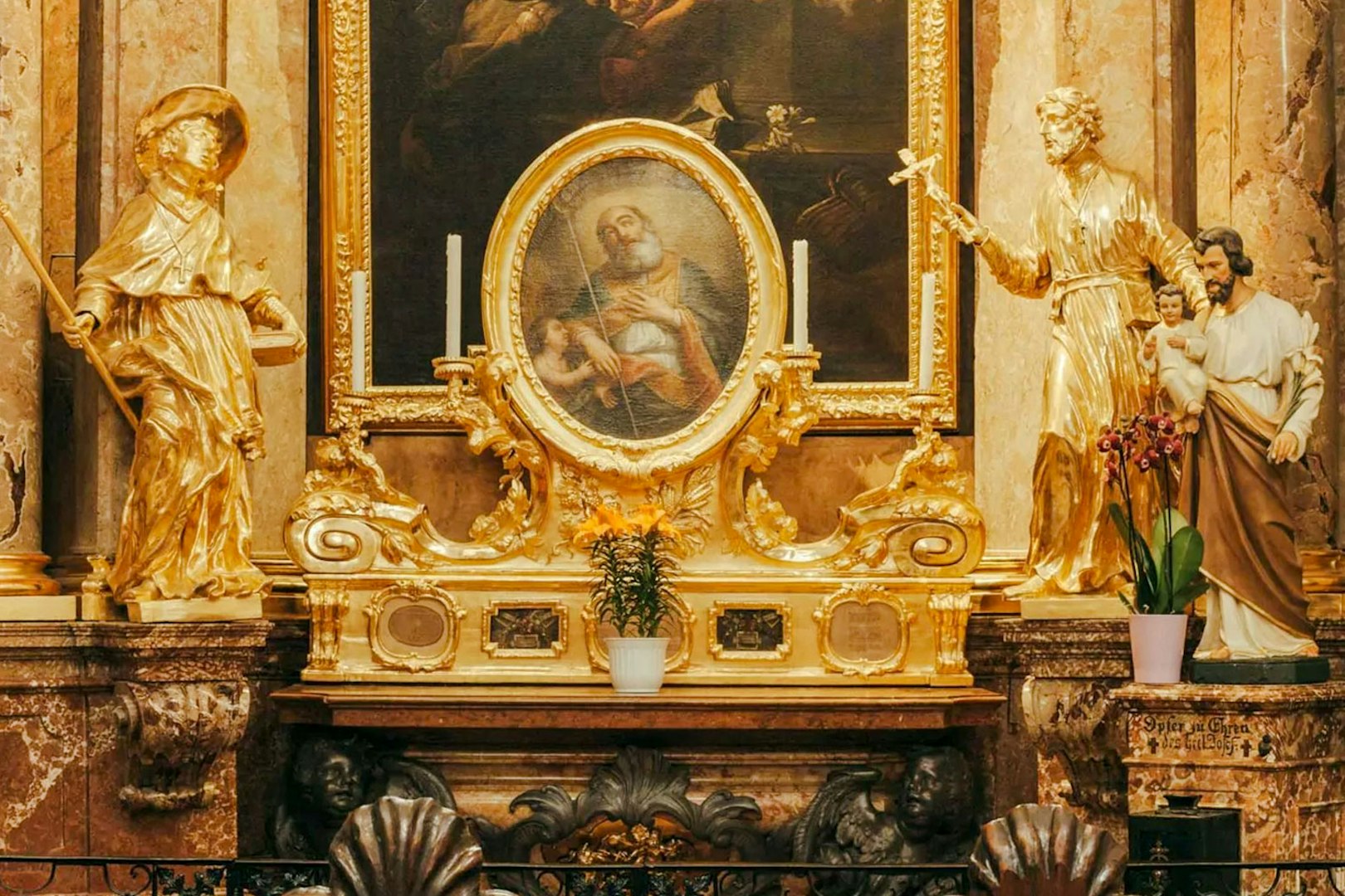 Golden altar with religious statues and painting inside St Anne's Church.