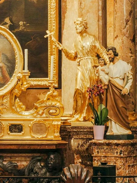 Golden altar with religious statues and painting inside St Anne's Church.