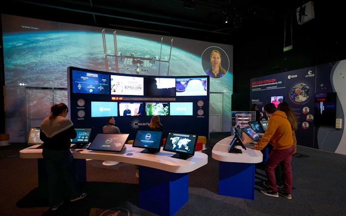 Interactive space exhibit at Cité de l’Espace, France, featuring mission control displays and educational screens.