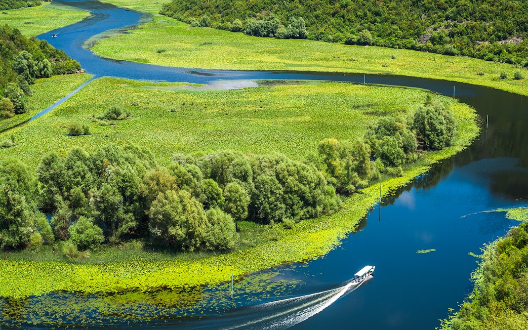 Crnojevica river bends and curves with boat in Montenegro.