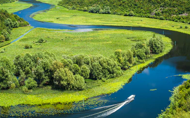 Crnojevica river bends and curves with boat in Montenegro.