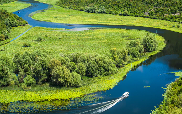Crnojevica river bends and curves with boat in Montenegro.