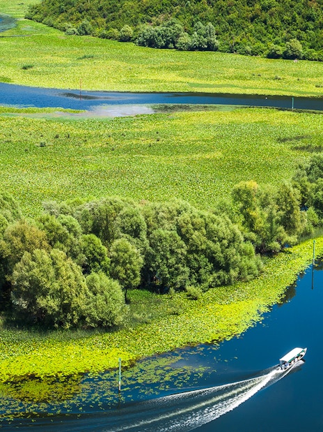 Crnojevica river bends and curves with boat in Montenegro.