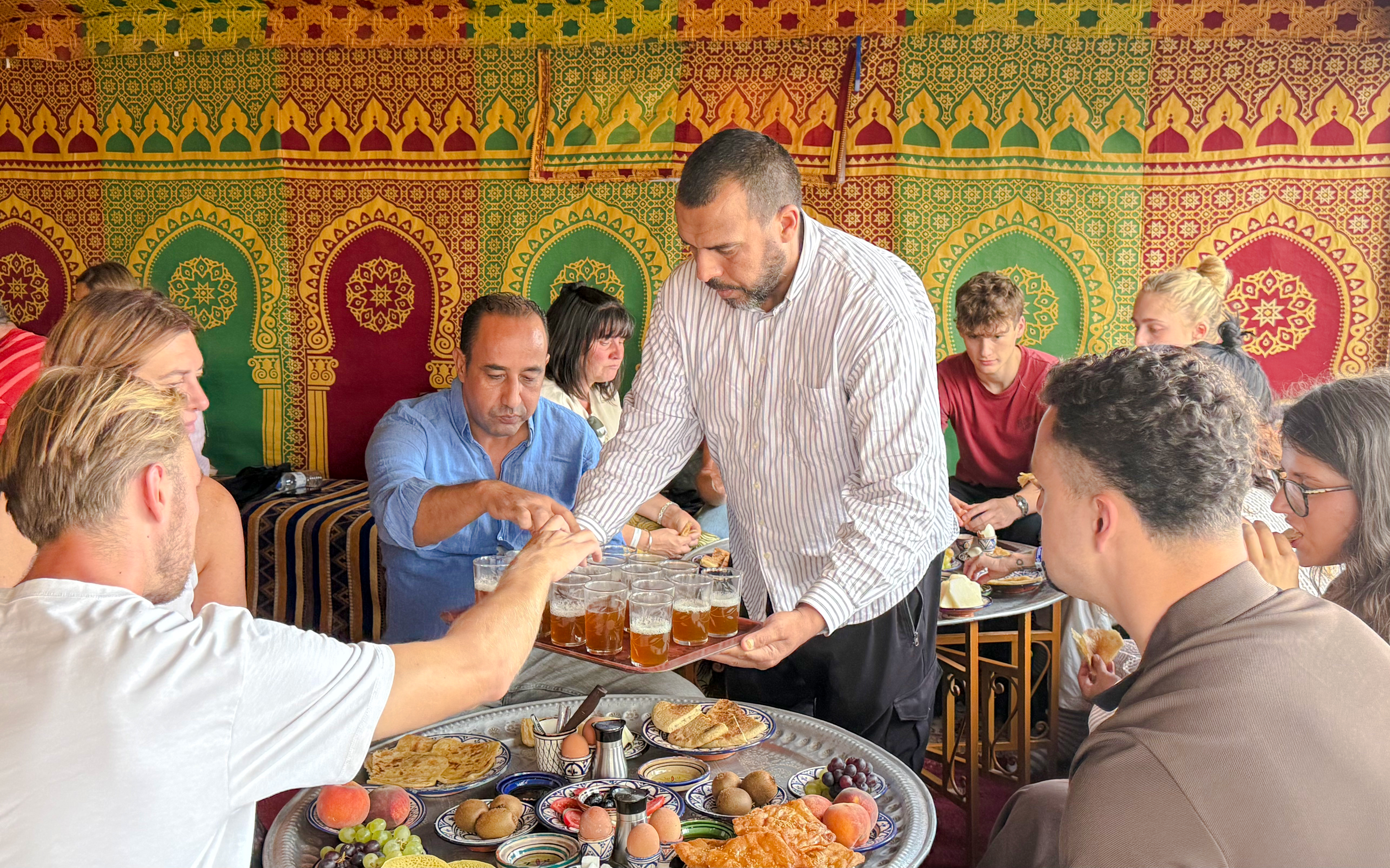 Man serving traditional Berber breakfast in caidal tent after hot air balloon ride, Marrakech.