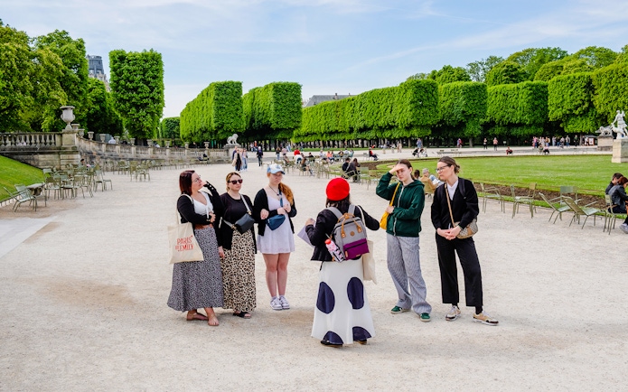Guide with tourists in a Paris park during Emily in Paris Locations Walking Tour.