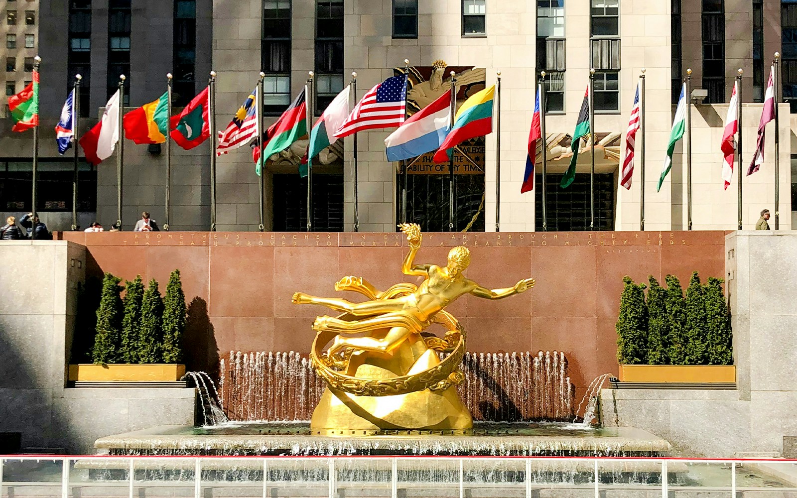 Prometheus statue with international flags at Rockefeller Center, Manhattan, NY.