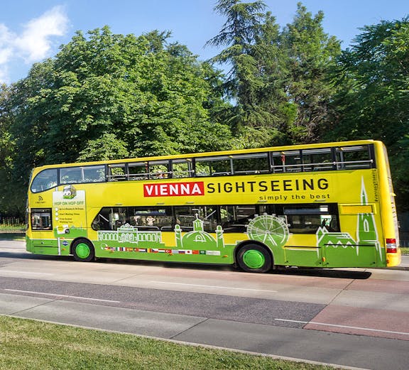 Vienna sightseeing hop-on hop-off bus on a tree-lined street.