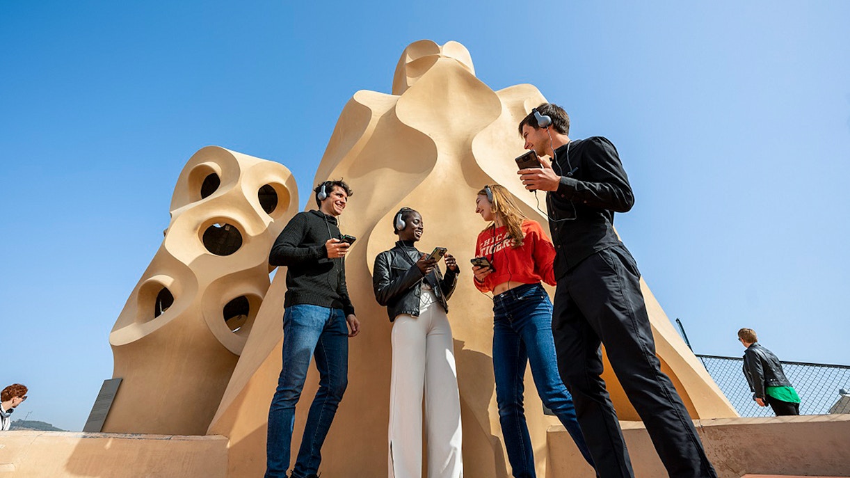 Visitors with audio guides at La Pedrera-Casa Milà rooftop in Barcelona.