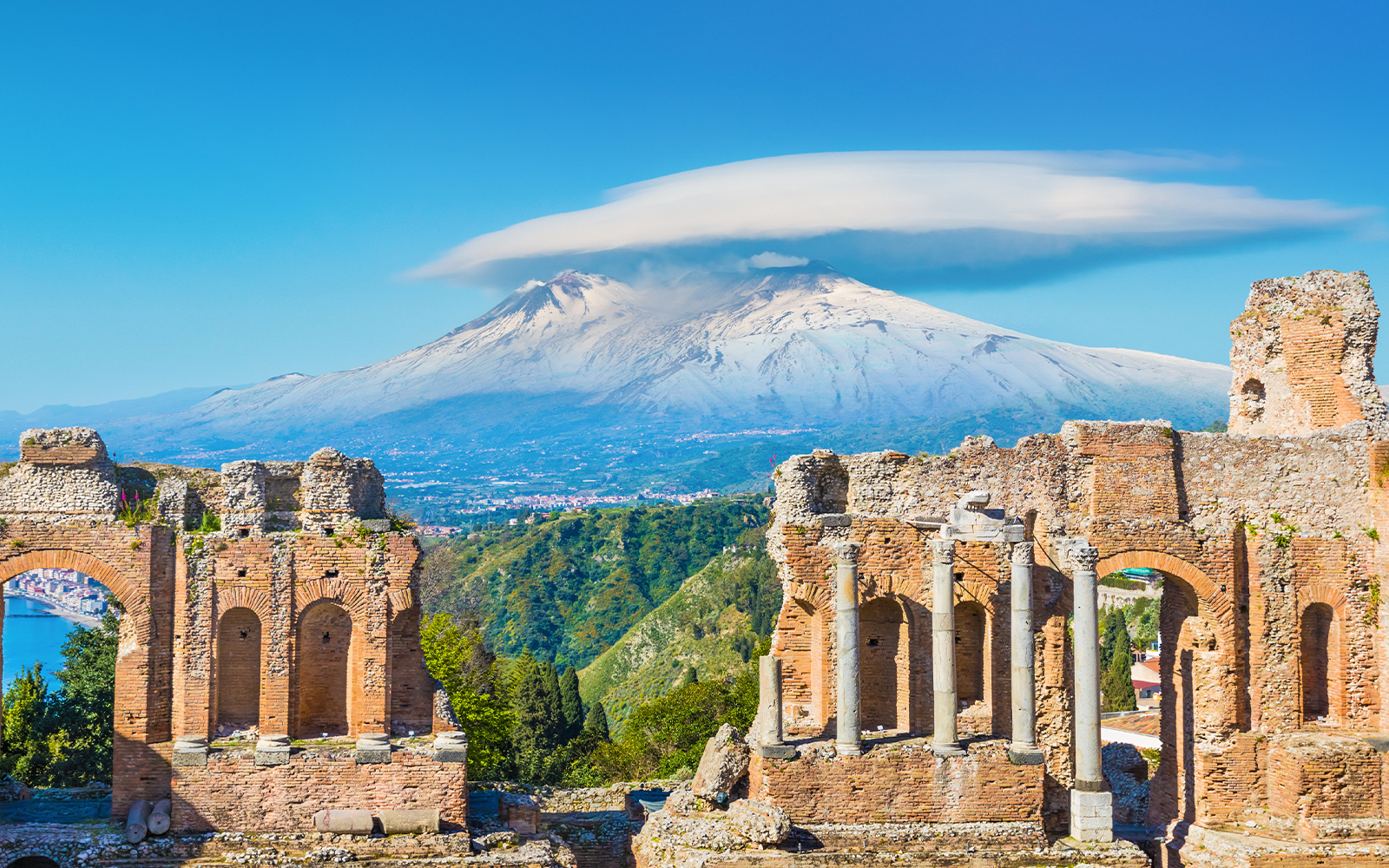 Ancient Greek theatre in Taormina with Mount Etna on background