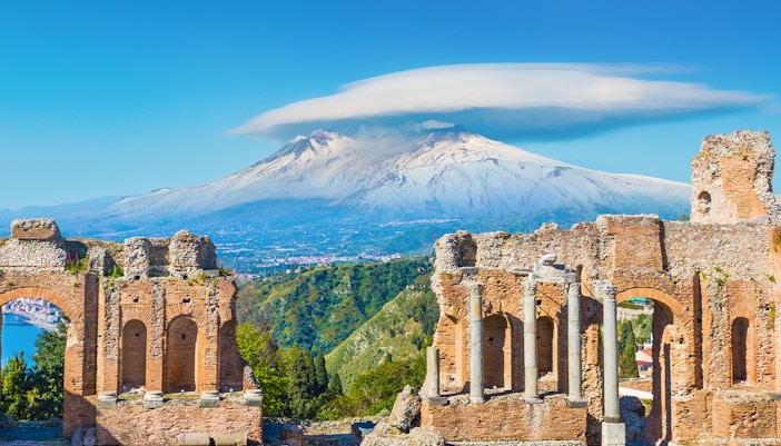 Ancient Greek theatre in Taormina with Mount Etna on background