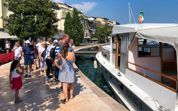 Tourists boarding a boat for a 4-hour cruise on Lake Garda to Sirmione.