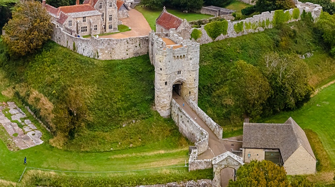 Aerial view of Carisbrooke Castle, Isle of Wight, featuring stone walls and surrounding greenery.