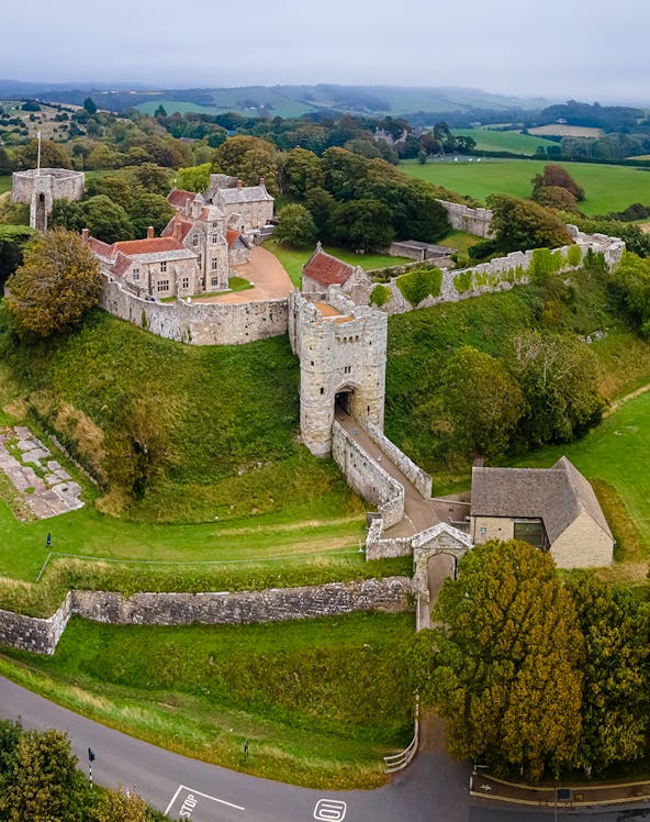 Aerial view of Carisbrooke Castle, Isle of Wight, featuring stone walls and surrounding greenery.