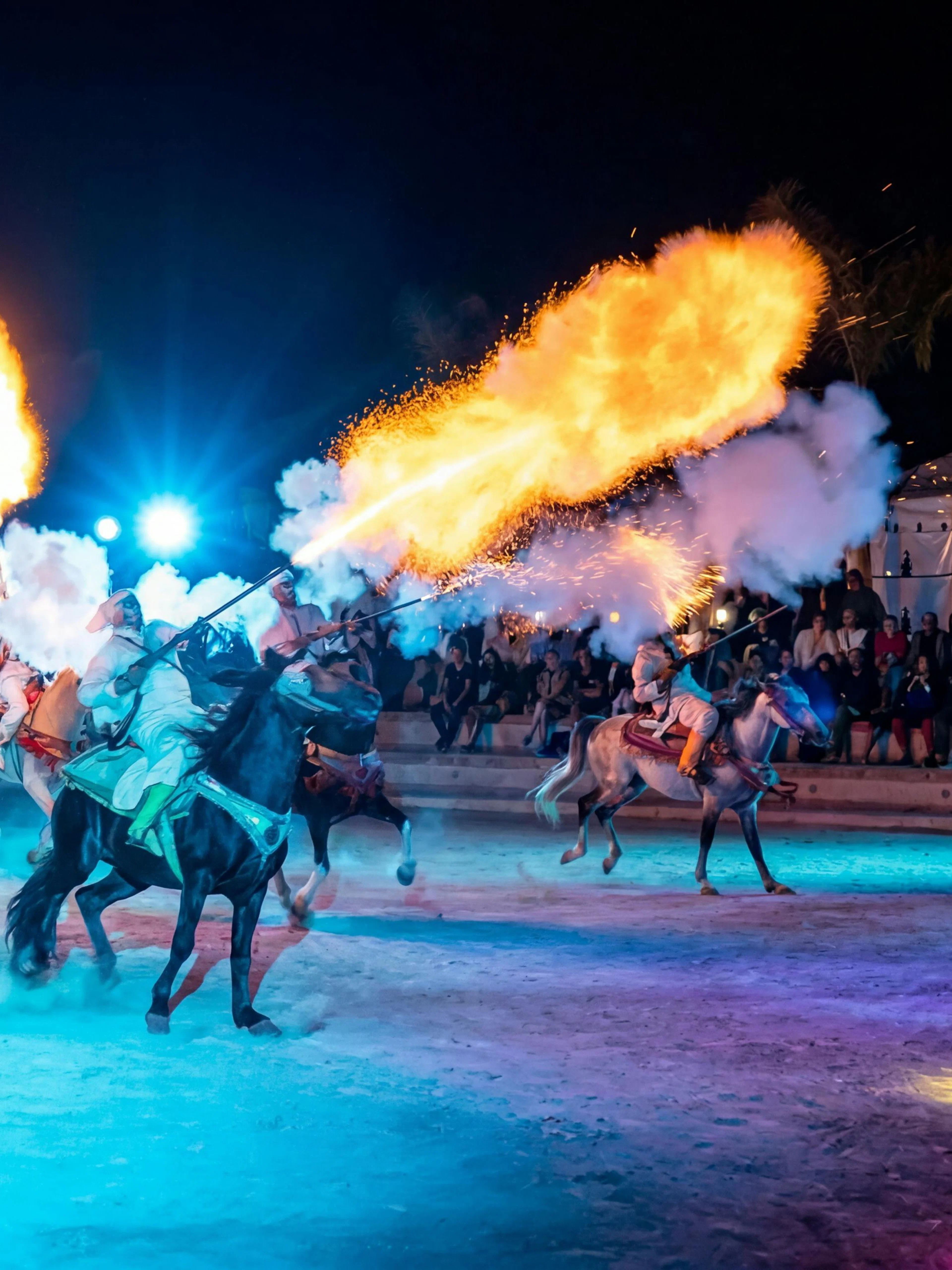 Berber horsemen performing with fire at Agadir Fantazia night show.