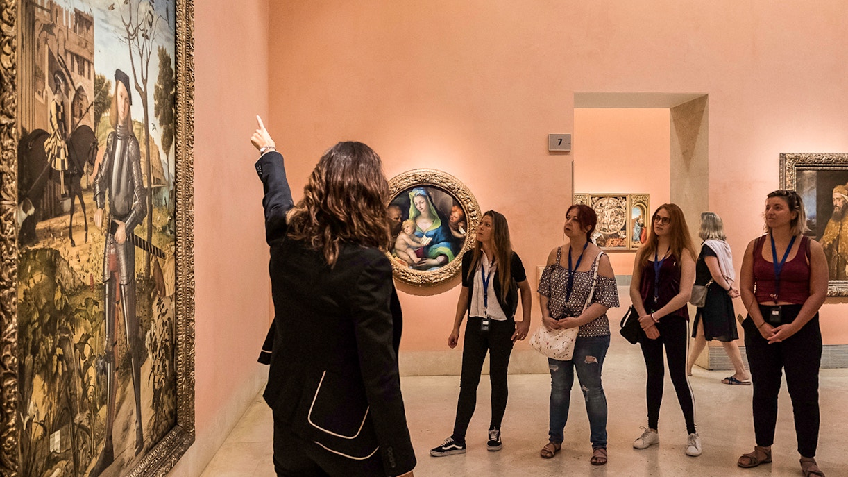 Tour guide explaining artwork to visitors at Thyssen Museum, Madrid.