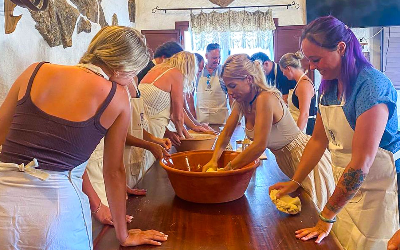 Participants kneading dough at a Sardinian pasta workshop in Olbia.