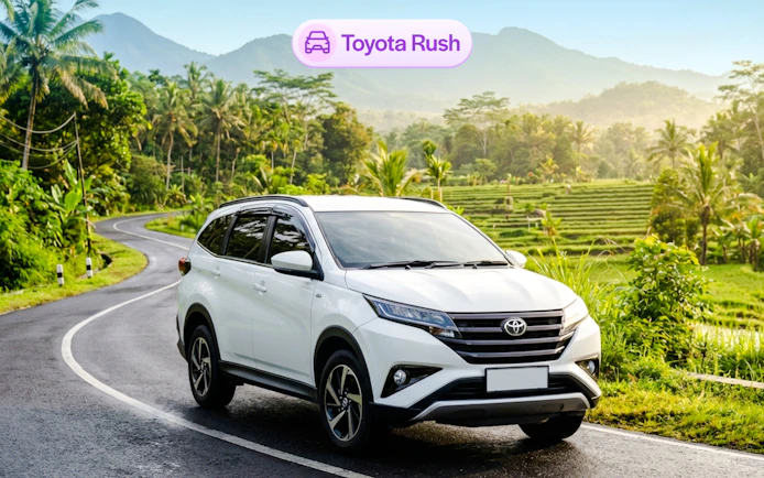 Toyota Rush rental car on scenic Bali road with rice terraces.