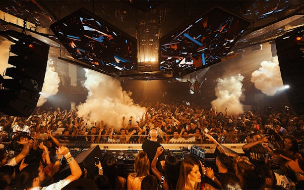 DJ performing at Music On event in Pacha Ibiza nightclub with vibrant lights.