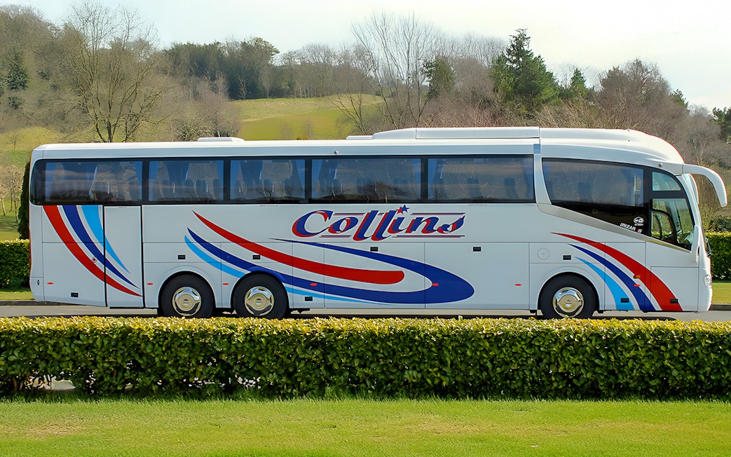 Tour coach parked in a scenic countryside setting.