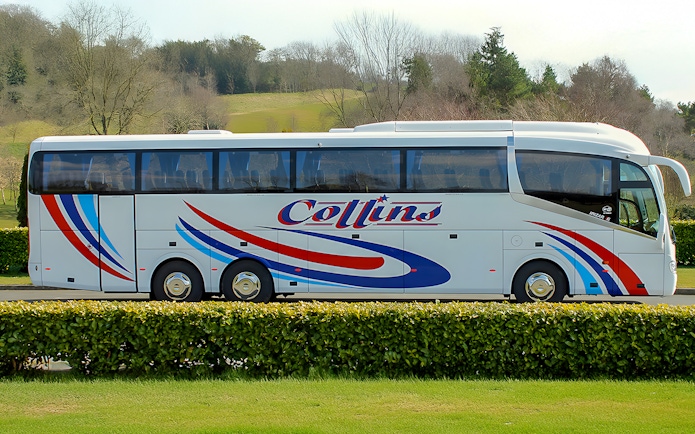 Tour coach parked in a scenic countryside setting.